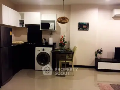 Modern kitchen with washing machine and dining area in cozy apartment