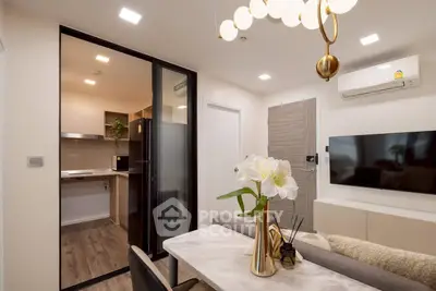 Modern living room with open kitchen, stylish decor, and elegant lighting in a contemporary apartment.