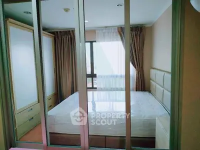 Spacious bedroom with large mirrored wardrobe and natural light