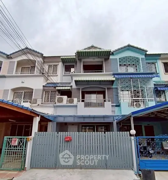 Charming three-story townhouse with modern facade and gated entrance.