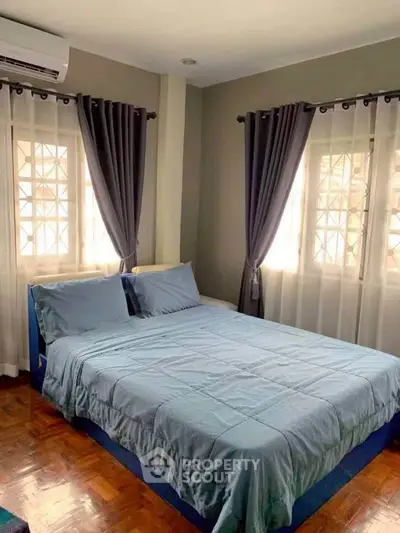 Cozy bedroom with elegant curtains and polished wooden floor