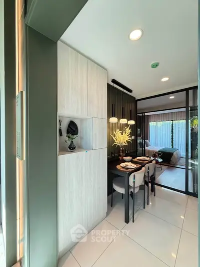 Modern open-plan living space with dining area and bedroom, featuring sleek design and natural light.