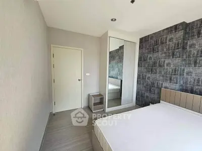 Modern bedroom with stylish decor and mirrored wardrobe