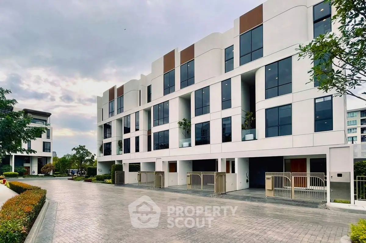 Modern multi-story residential building with sleek design and spacious driveways.