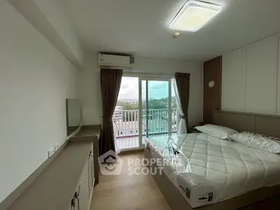 Modern bedroom with balcony and scenic view, featuring a cozy bed and stylish decor.