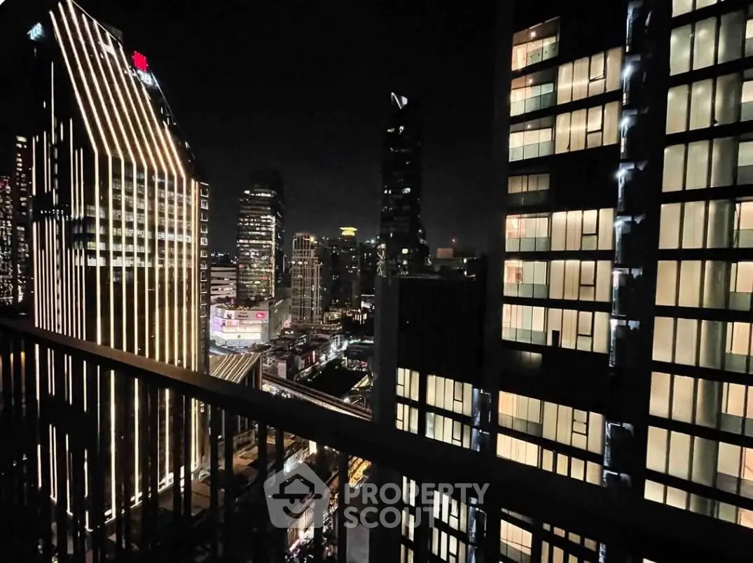 Stunning night view of city skyline from high-rise balcony, showcasing illuminated skyscrapers and vibrant urban life.