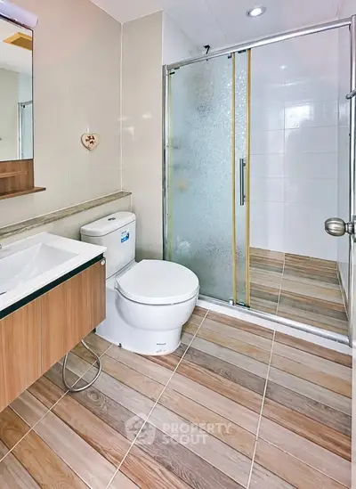 Modern bathroom with glass shower and wood-style tile flooring