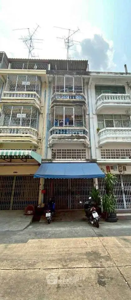Charming multi-story building with balconies and street view, ideal for urban living.