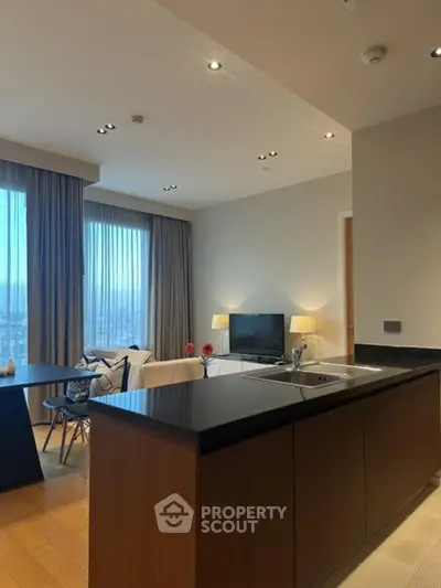 Modern open-plan living room with sleek kitchen island and large windows.