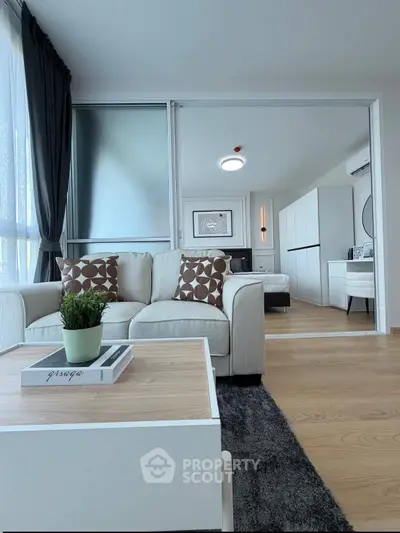 Modern living room with stylish decor and view into a chic bedroom