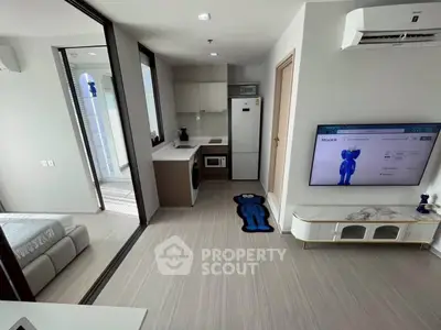 Modern apartment interior with sleek kitchen and cozy living area, featuring stylish decor and efficient layout.