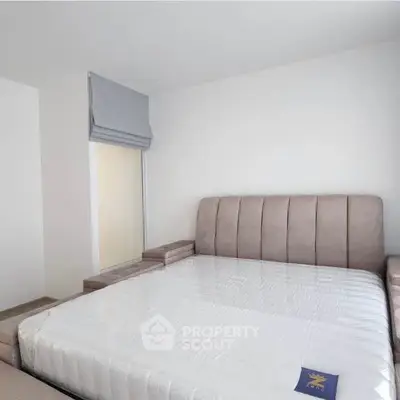 Spacious bedroom with modern bed and minimalist decor, perfect for relaxation and comfort.