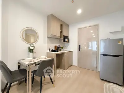 Modern kitchen with dining area, featuring sleek cabinetry and stainless steel appliances.