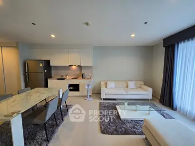 Spacious modern living room with open kitchen, elegant dining area, and cozy seating, perfect for stylish urban living.