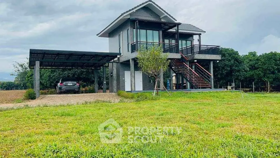 Charming two-story house with carport and lush green surroundings, perfect for serene living.