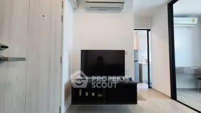 Modern living room with sleek TV setup and air conditioning in a stylish apartment.