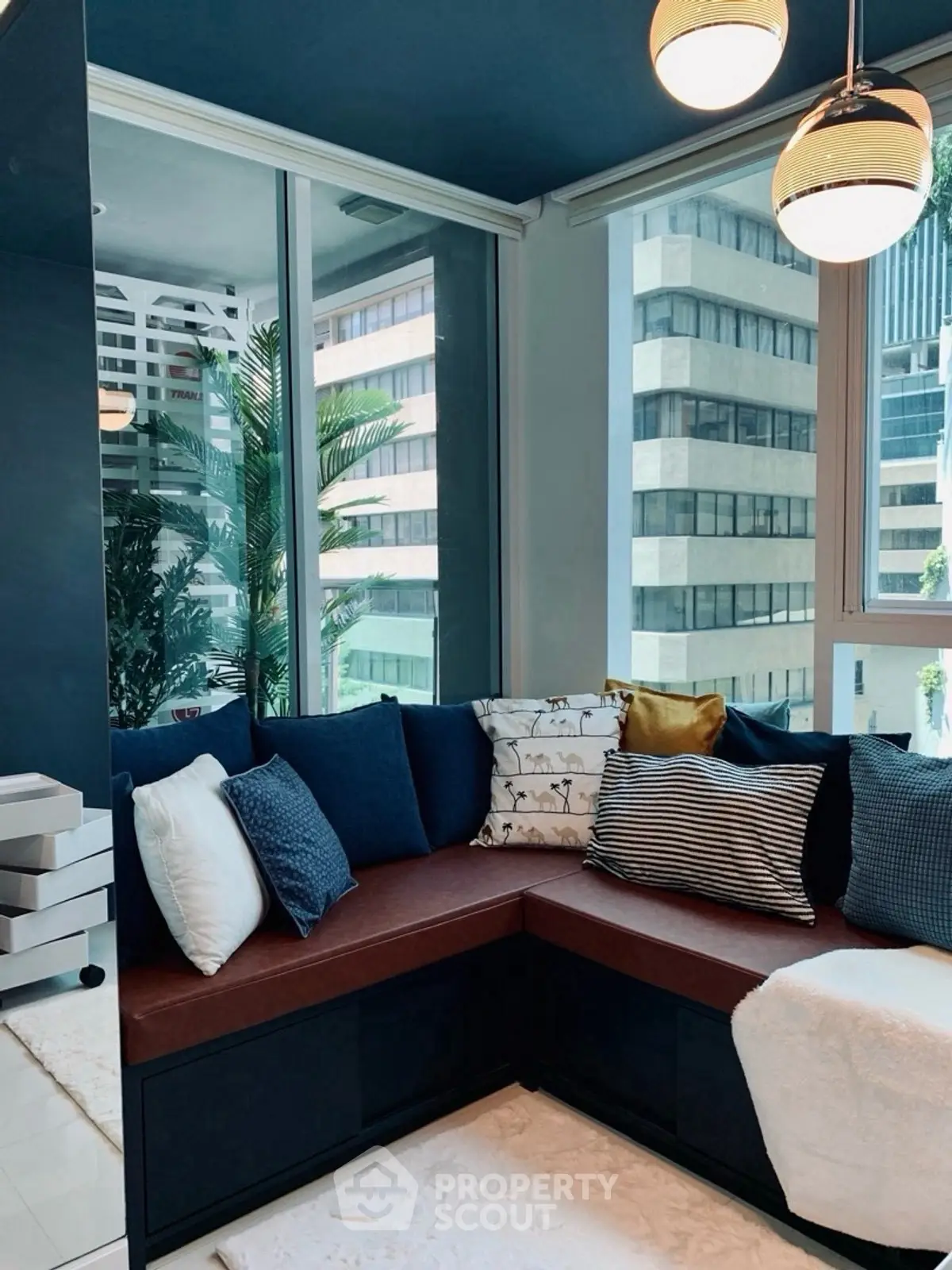 Stylish modern living room with cozy corner seating and city view.