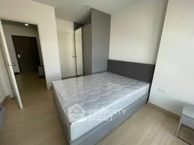 Modern bedroom with sleek design and ample natural light, featuring a comfortable bed and stylish wardrobe.