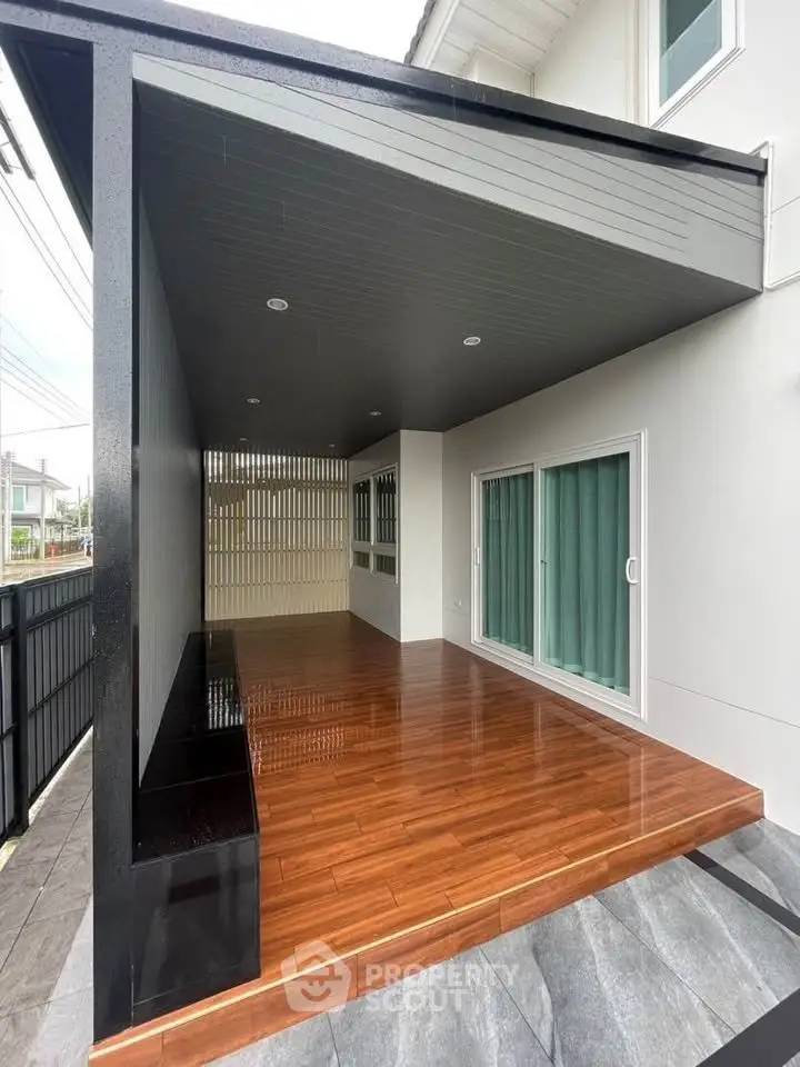 Modern home exterior with sleek wooden deck and sliding glass doors