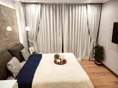 Cozy bedroom with elegant decor and floor-to-ceiling curtains