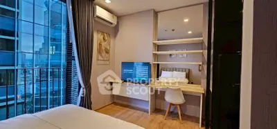 Modern bedroom with city view, featuring a sleek desk and wall-mounted TV.
