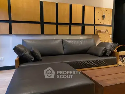 Modern living room with stylish leather sofa and wooden accents, perfect for contemporary urban living.