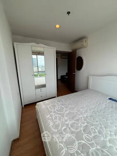 Bright bedroom with modern wardrobe and air conditioning, offering a cozy and comfortable living space.