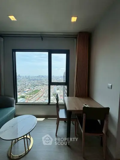 Modern living room with stunning city view from large window, featuring elegant furniture.