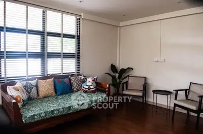 Charming living room with cozy seating and large windows, perfect for relaxation and natural light.
