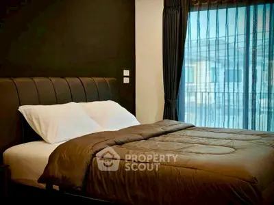 Luxurious bedroom with elegant decor and large window view.