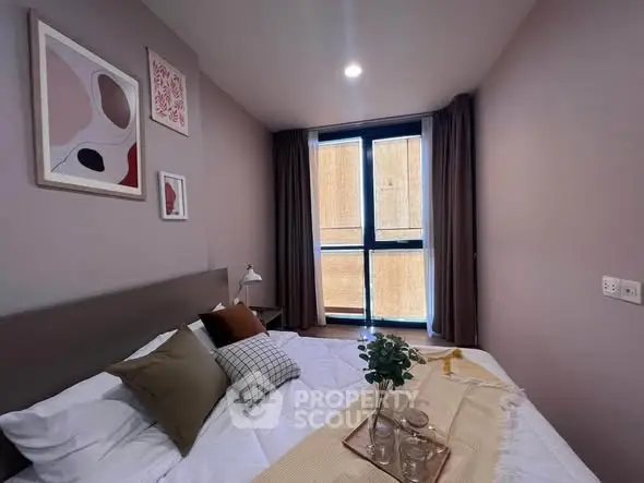 Cozy bedroom with modern decor and large window for natural light.