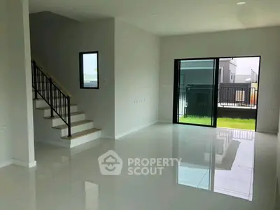 Spacious modern living room with glossy floors and large windows opening to a garden view.