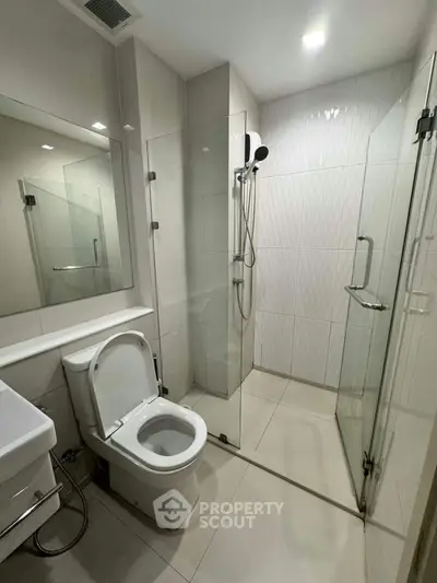 Modern bathroom with glass shower enclosure and sleek fixtures