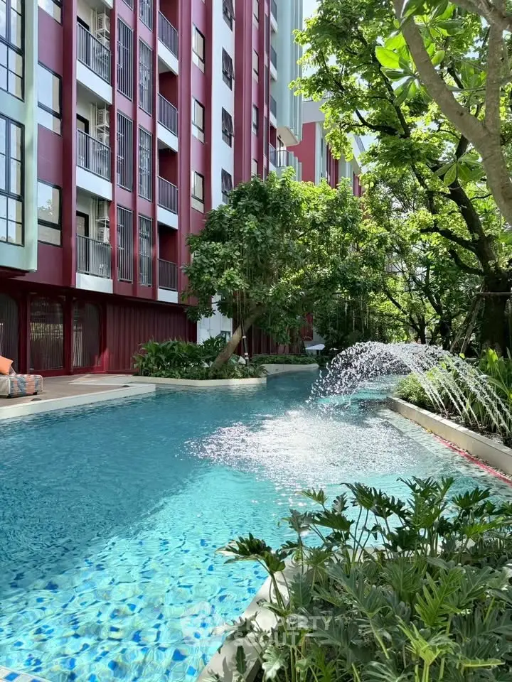 Luxurious apartment building with sparkling pool and lush greenery, perfect for relaxation and leisure.