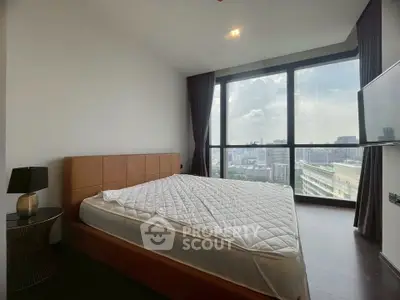Modern bedroom with large windows offering stunning city views