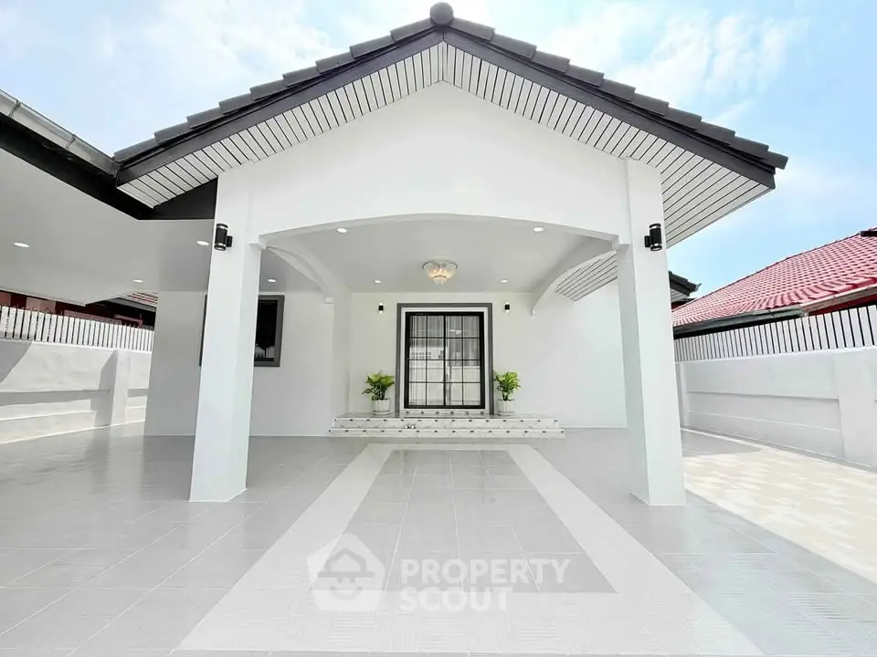 Modern white house exterior with sleek roof design and spacious driveway