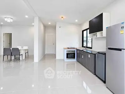 Modern open-plan kitchen with sleek appliances and dining area in bright, spacious interior.