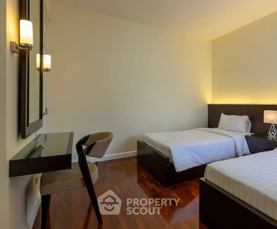 Modern bedroom with twin beds and sleek wooden flooring