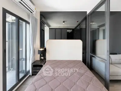 Modern bedroom with large windows and sleek design in a contemporary apartment.