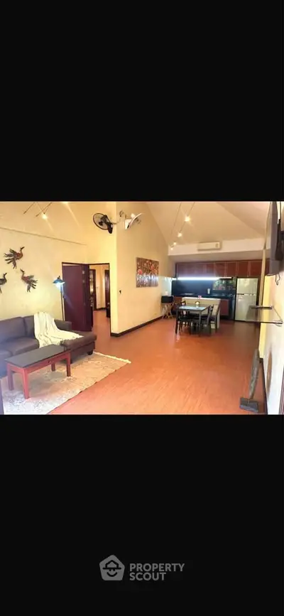 Spacious open-plan living room with modern kitchen and cozy seating area.