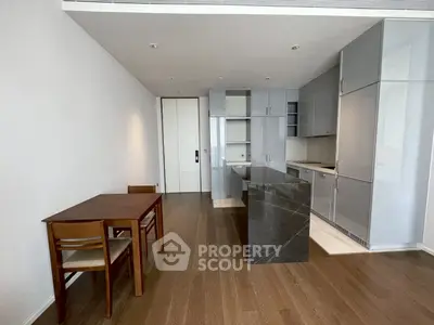 Modern kitchen with sleek cabinetry and island in open layout apartment.
