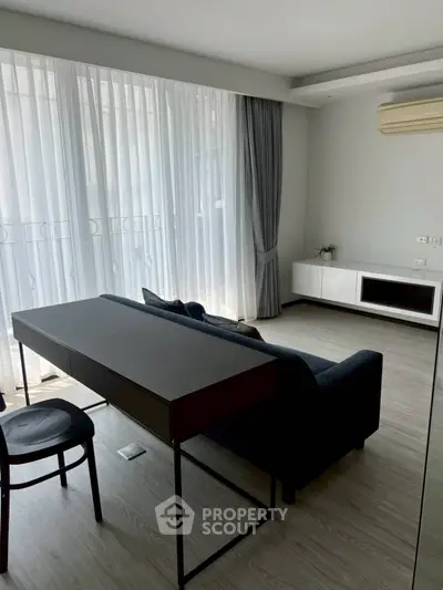 Modern living room with sleek furniture and large windows for natural light.