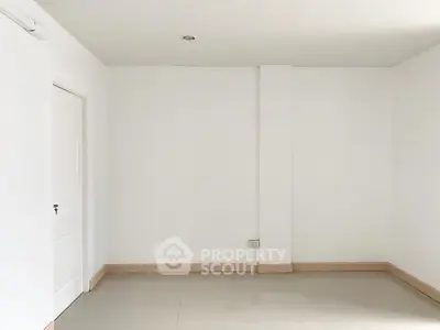 Spacious empty room with white walls and tiled floor, ready for customization.