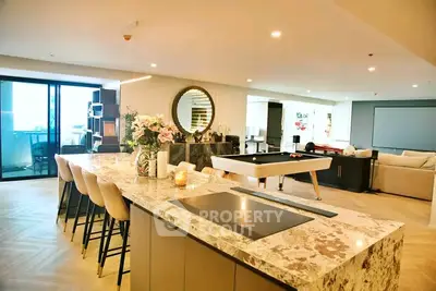 Luxurious open-plan kitchen and living area with modern decor and pool table, perfect for entertaining.