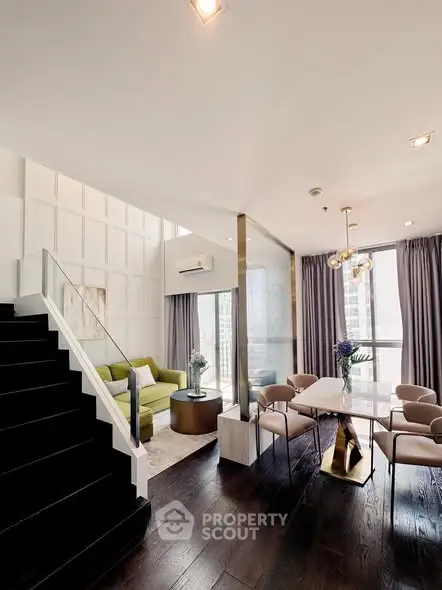Luxurious modern living room with elegant dining area and stylish staircase in high-rise apartment.