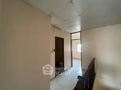 Spacious hallway with natural light and tiled flooring in a residential property.