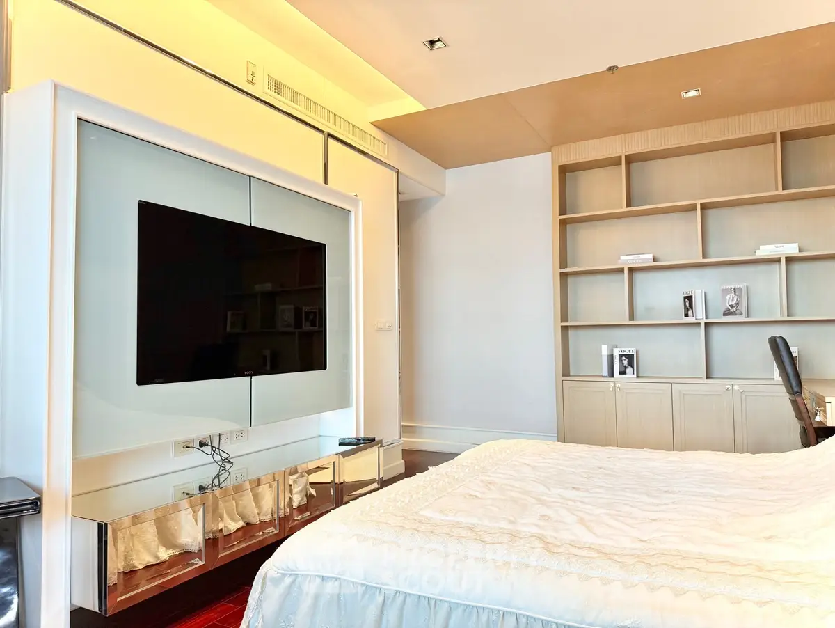 Luxurious bedroom with modern TV setup and elegant shelving