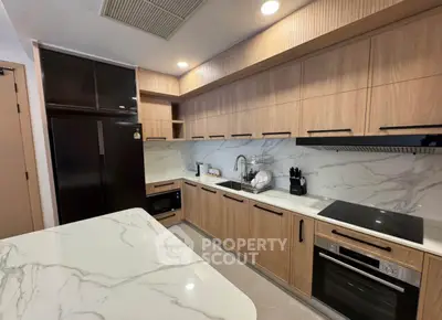 Modern kitchen with sleek cabinetry and marble countertops, featuring built-in appliances and ample storage.