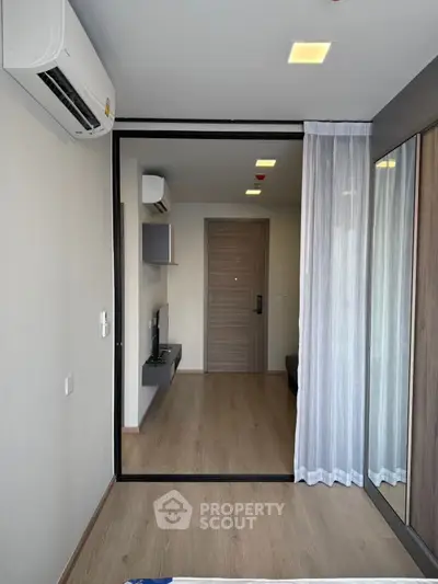 Modern living room with wooden flooring and large windows