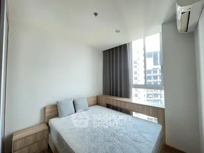 Modern bedroom with large window and minimalist decor in high-rise apartment.